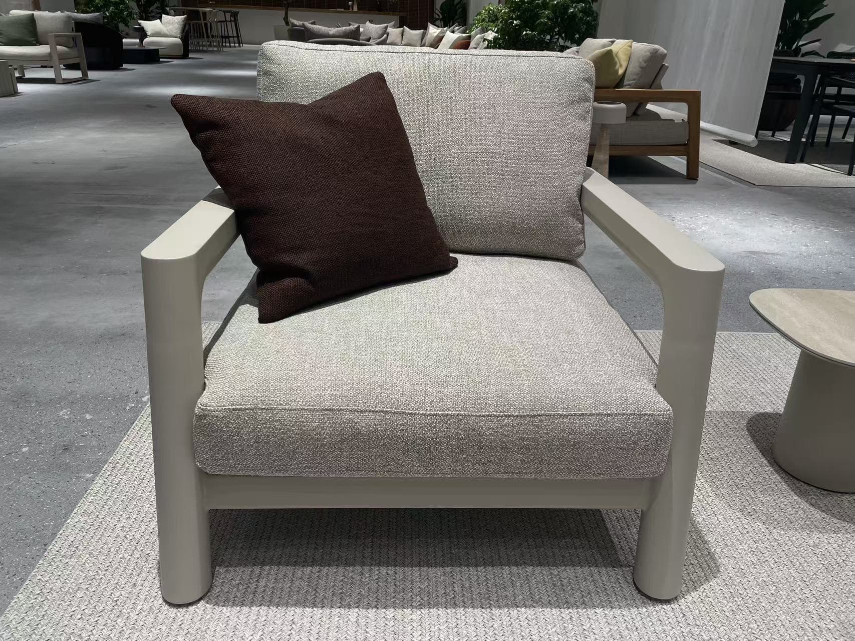 A rectangular outdoor coffee table with a dark gray, textured top and four sturdy, dark gray legs is shown on a speckled gray floor.
